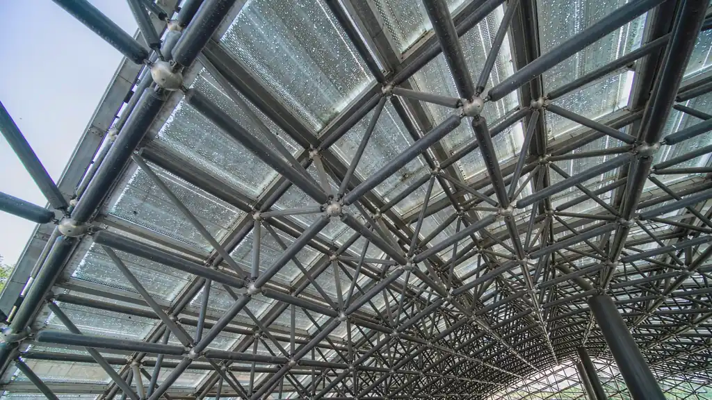 Steel space frame canopy with tubular members and skylight panels over a walkway